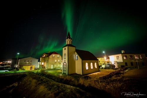 an old church with the aurora in the sky at Hótel Blönduós in Blönduós