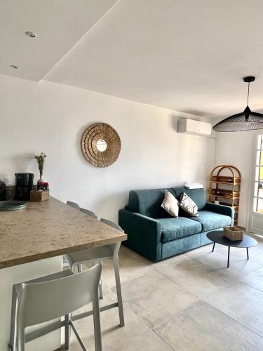 un salon avec un canapé bleu et une table dans l'établissement Appartement 2-4 pers, ACCES DIRECT MER, à Casaglione