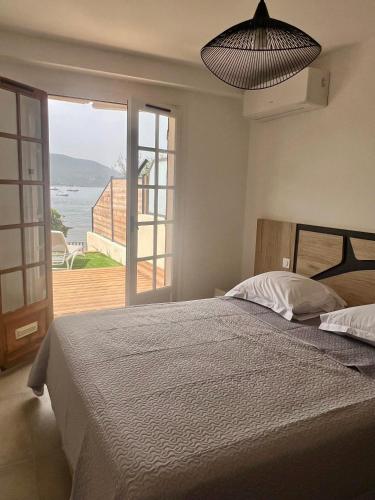 une chambre avec un lit avec vue sur l'océan dans l'établissement Appartement 2-4 pers, ACCES DIRECT MER, à Casaglione