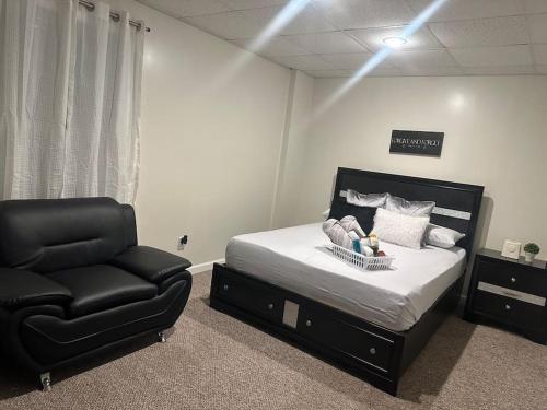 ein Schlafzimmer mit einem Bett und einem schwarzen Stuhl in der Unterkunft Home away from home! in Canton