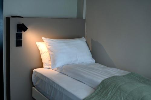 a bed with white sheets and a white pillow at Hotel Local 101 in Reykjavík