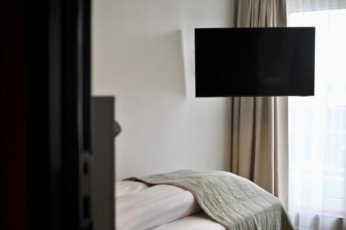 a bedroom with a bed and a lamp and a window at Hotel Local 101 in Reykjavík
