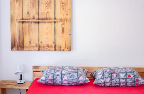 a bed with two pillows on top of it at Apartmaji Pri Kozmavo - Little House in Bohinj