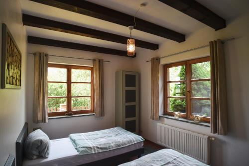a bedroom with two beds and two windows at Landhaus Charlotte - Feldblick in Wassersuppe