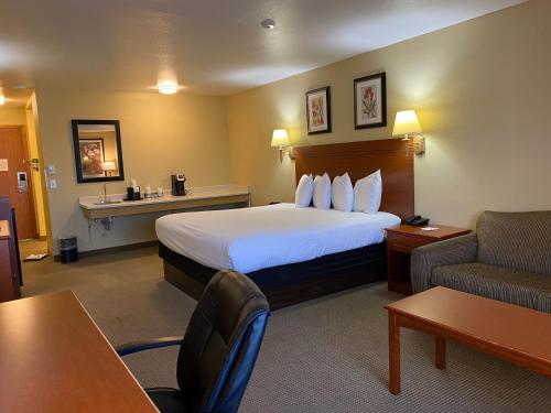 um quarto de hotel com uma cama grande e um sofá em Wingate by Wyndham Mount Vernon em Mount Vernon