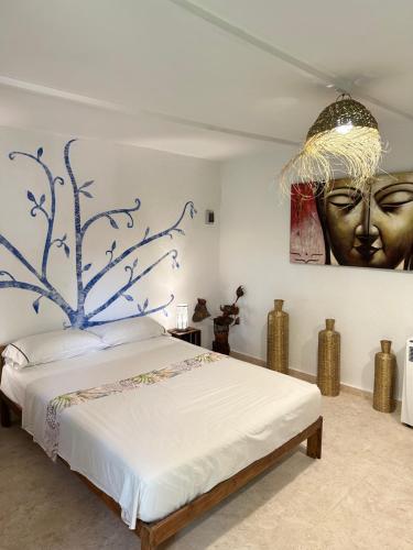 a bedroom with a bed with a painting on the wall at New Paradaise art Gallery in Xàtiva