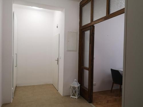 einen Flur mit einer Tür, einem Tisch und einem Stuhl in der Unterkunft Apartmán Dlouhá 207 in Leitmeritz