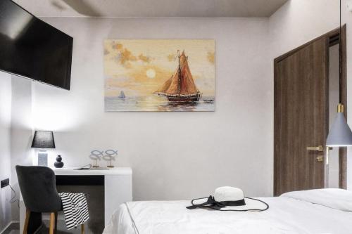a bedroom with a bed and a painting on the wall at Menda Suite in Heraklio Town
