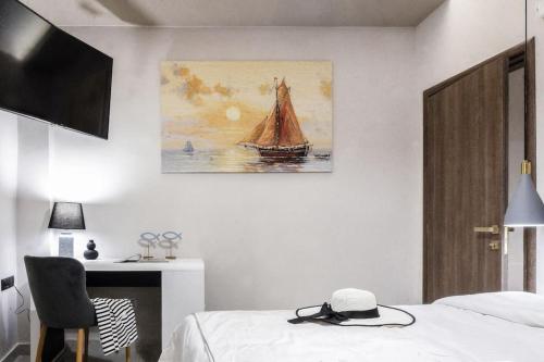 une chambre avec un lit et un tableau au mur dans l'établissement Menda Suite, à Héraklion