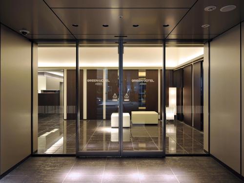 a lobby with glass doors with a couch in it at Hakata Green Hotel Annex in Fukuoka