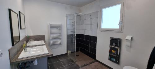 La salle de bains est pourvue d'un lavabo, d'une douche et d'une fenêtre. dans l'établissement Villa Chrysalide, à Berrias Et Casteljau