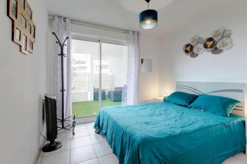 1 dormitorio con cama azul y puerta corredera de cristal en *ALCO Appart 2 chambres, WIFI, Parking, Terrasses*, en Montpellier