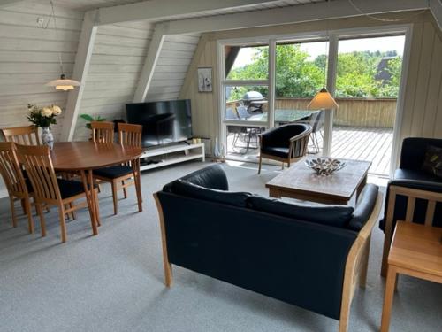 uma sala de estar com um sofá e uma mesa em Nice holiday home in beautiful resort em Farsø