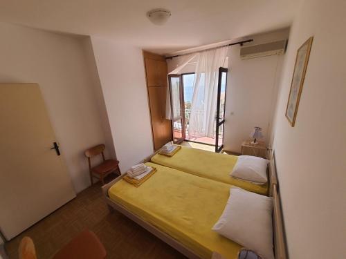 mały pokój z 2 łóżkami i oknem w obiekcie Apartments Andjus w miejscowości Sveti Stefan