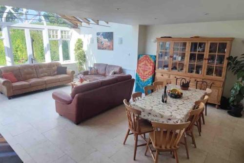 a living room with a table and chairs and a couch at Traditional New Forest cottage in Brockenhurst. in Brockenhurst