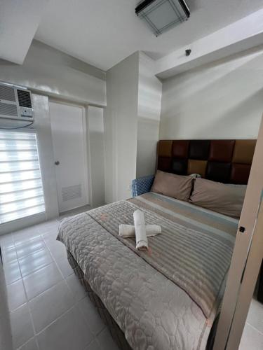 a bedroom with a bed with a towel on it at Netflix and Unli WIFI!!! The Elchies Room at Tagaytay Prime Residence in Tagaytay