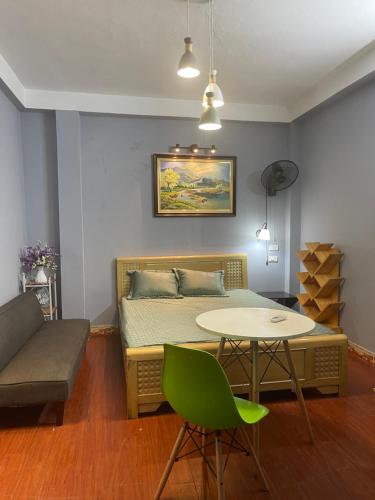 a bedroom with a bed and a table and a couch at Cozy Homestay in Hanoi