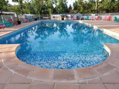 una piscina con agua azul en el medio en Mobil-home de vacances, en Le Bosc