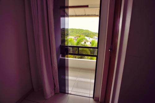 an open window with a view of a balcony at Pousada Paulett's - Hospedagem na Zona Norte de Ilhéus - Bahia in Ilhéus