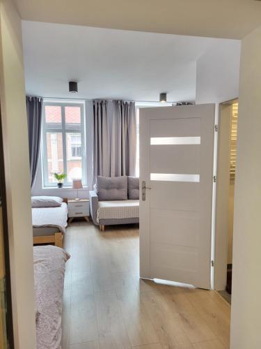 グリヴィツェにあるSARA Pokoje - Studio Gliwiceの白い部屋(ドア付)とベッドルーム1室