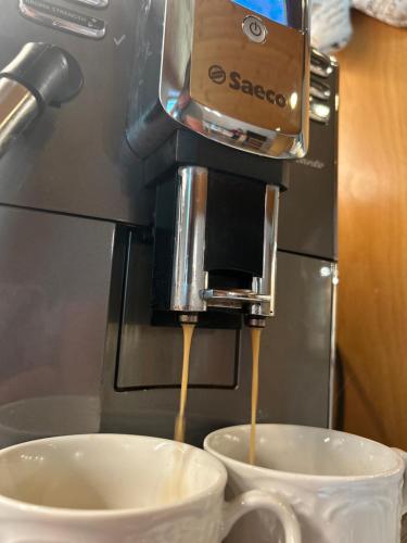 eine Kaffeemaschine schüttet Kaffee in eine Tasse in der Unterkunft Ferienwohnung Tux in Tux