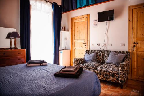 sypialnia z łóżkiem i kanapą w obiekcie Bobo House Calasetta w mieście Calasetta