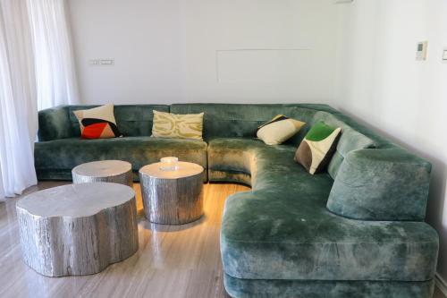 sala de estar con sofá verde y 2 mesas de tocón en Luxurious Coastal Villa with Pool Near the Beach by Sea N' Rent, en Herzliya