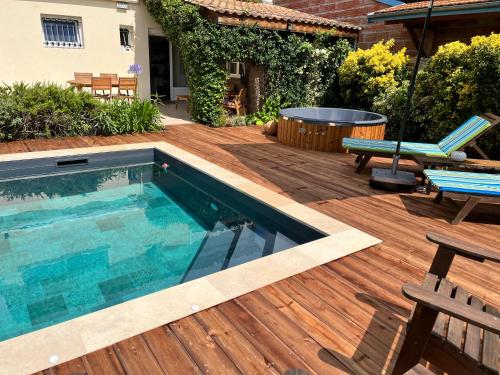 um quintal com uma piscina e um deque de madeira em Les Suites d'Aliénor, Suite Jasmin em Pessac
