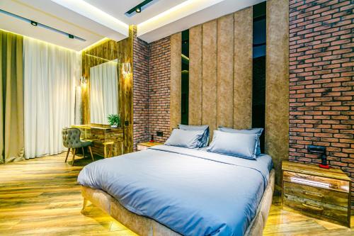 a bedroom with a large bed and a dining room at Park Vurğun Residance Loft Designer in Baku