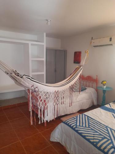 a hammock in a bedroom with two beds at Casa Hostal Perla Roja in Ríohacha