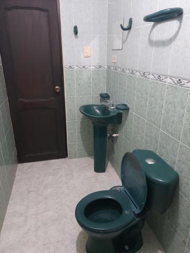 a bathroom with a black toilet and a sink at Casa Hostal Perla Roja in Ríohacha