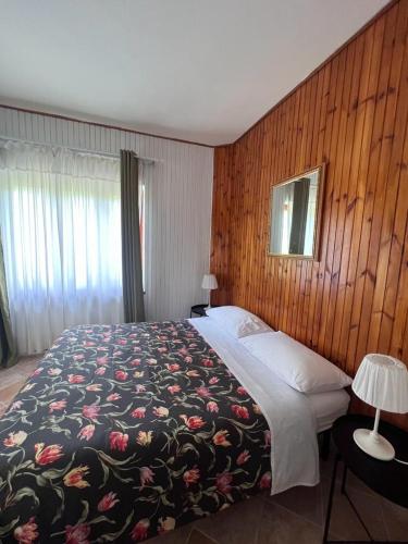 a bedroom with a large bed with a floral blanket at L'Orsa in Villalago