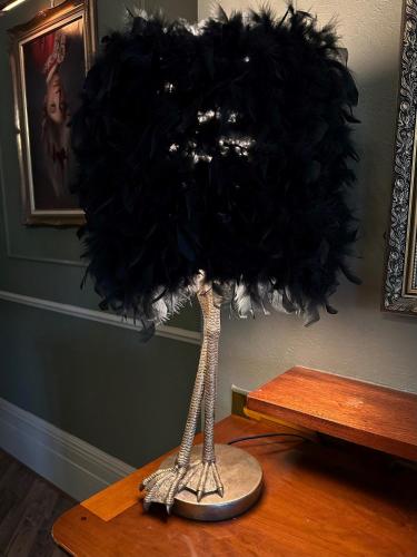 a black feather lamp on a wooden table at The Q Hotel in Shanklin