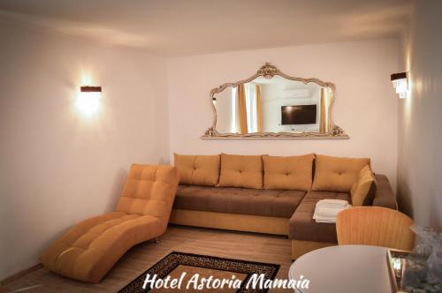 sala de estar con sofá y espejo en Hotel Astoria en Mamaia