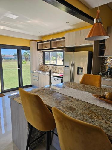 a kitchen with a large counter with yellow walls at Chuumba Villas in Lusaka