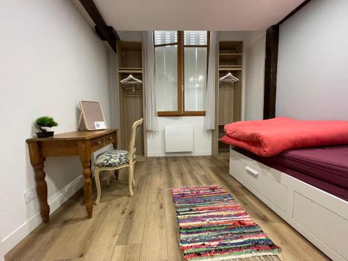 a bedroom with a desk and a bed with a red mattress at chambre cosy privée chez Franck in Bordeaux