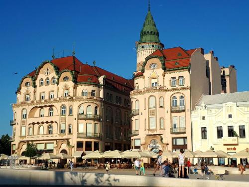 a group of buildings with people walking in front of them at Hanna's Apartament in Oradea