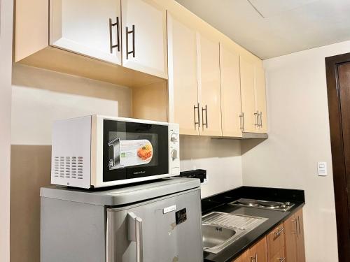 a kitchen with a microwave on top of a refrigerator at Kiel 5-Star Condo Hotel Across NAIA Manila Airport Terminal 3 in Manila