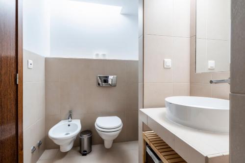a bathroom with a white toilet and a sink at Apartamento Salgados Beach in Albufeira