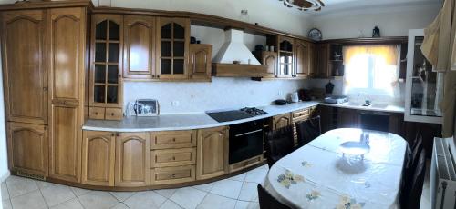 a kitchen with wooden cabinets and a table in it at Mariza's View House in Lákones