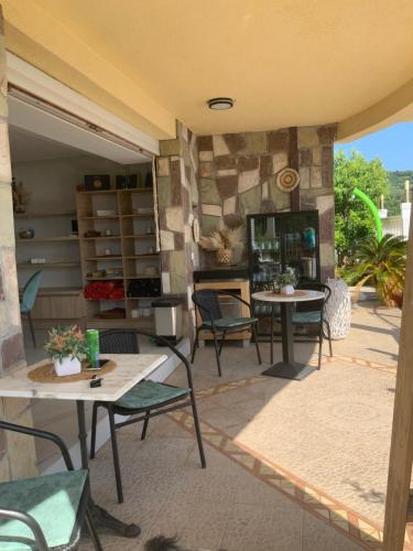 a patio with tables and chairs and a fireplace at Villa Apartmani Anja in Dobra Voda