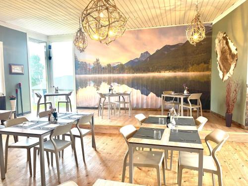a restaurant with tables and chairs and a painting on the wall at Klimpfjällsgården Hotel & Italian Restaurant in Klimpfjäll