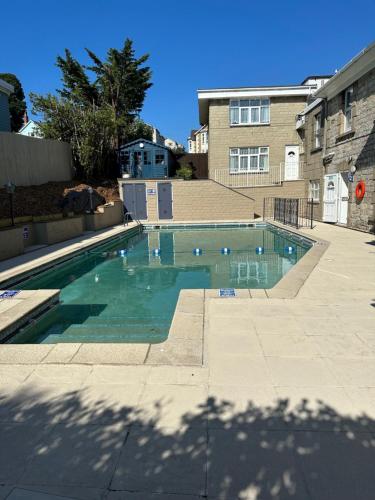 a swimming pool with blue water in a yard at The Q Hotel in Shanklin