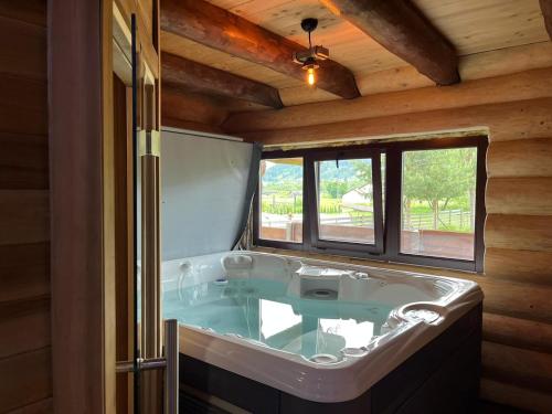 a large bath tub in a room with a window at Casa de Munte in Vatra Dornei
