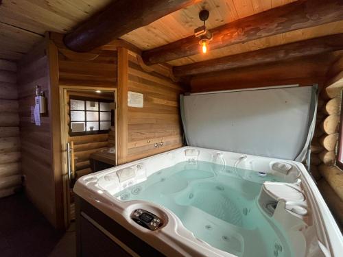 eine Whirlpool-Badewanne in einem Blockhaus in der Unterkunft Casa de Munte in Vatra Dornei