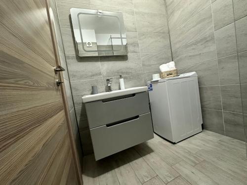 ein Bad mit einem Waschbecken und einem Spiegel in der Unterkunft Alfie Mamaia Nord in Mamaia Nord – Năvodari