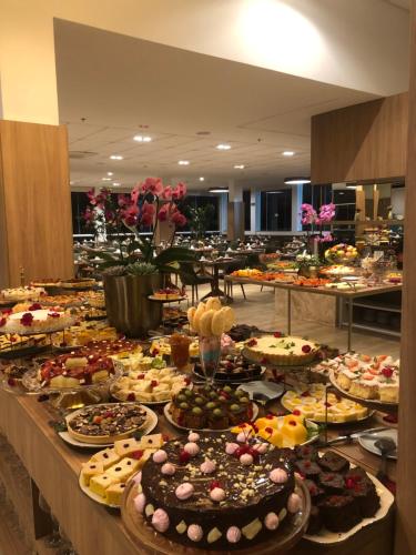 a buffet filled with lots of different types of cakes at Hotel Recanto Business Center in Restinga Sêca