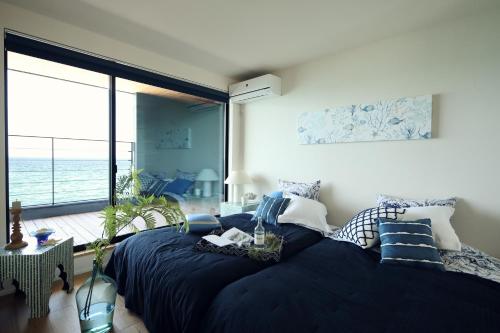 a bedroom with a large bed with a view of the ocean at tramonto.blu in Tusi