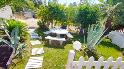 a backyard with a white fence and a table and chairs at Pupillo Casa Vacanza in Francavilla Fontana