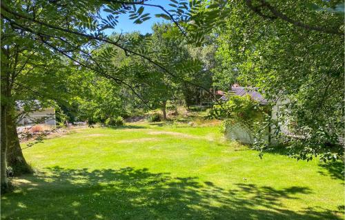 a yard with green grass and trees and a house at Nice Home In Bjällebäck With Wifi in Bjällebäck